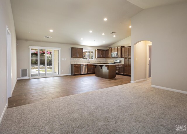 9029 Midnight Creek Way, Bakersfield, CA 93311 - kitchen with open floor plan, appliances with stainless steel finishes, arched walkways, a kitchen island, and light countertops
