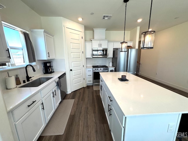 6722 Glacier Bay St, Bakersfield, CA 93313 - kitchen with stainless steel appliances, dark wood-style floors, a kitchen island, white cabinetry, and recessed lighting