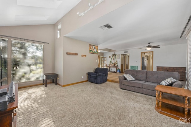 living room featuring ceiling fan, carpet, and lofted ceiling with skylight