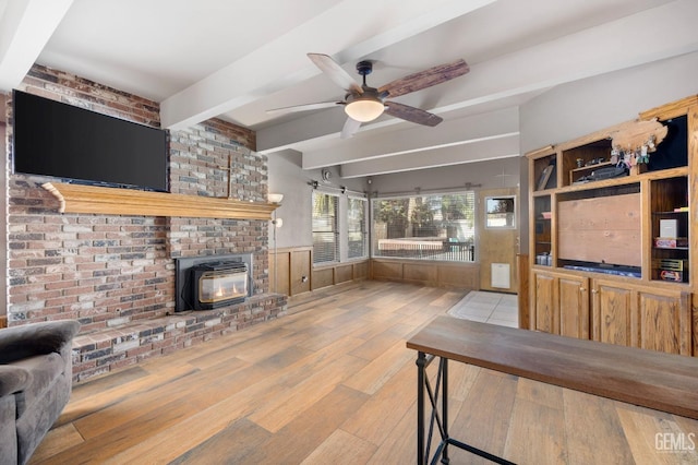 living room featuring ceiling fan, light hardwood / wood-style flooring, and beamed ceiling