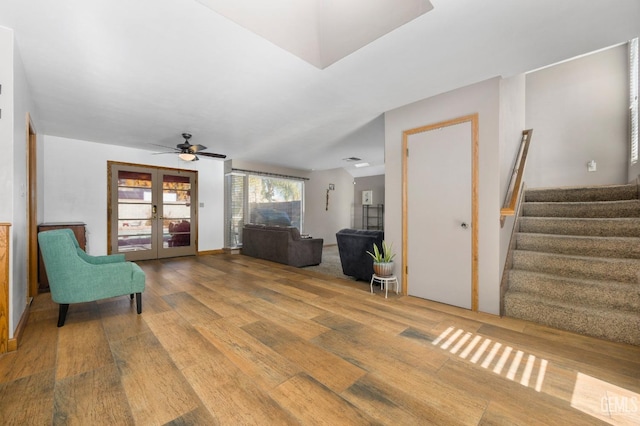 sitting room featuring hardwood / wood-style floors, ceiling fan, and french doors