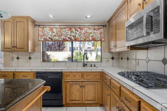 kitchen with appliances with stainless steel finishes, tasteful backsplash, light tile patterned floors, and sink