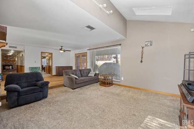 carpeted living room with a skylight and ceiling fan