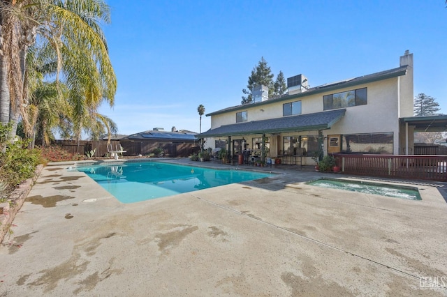 view of swimming pool featuring an in ground hot tub, central air condition unit, and a patio