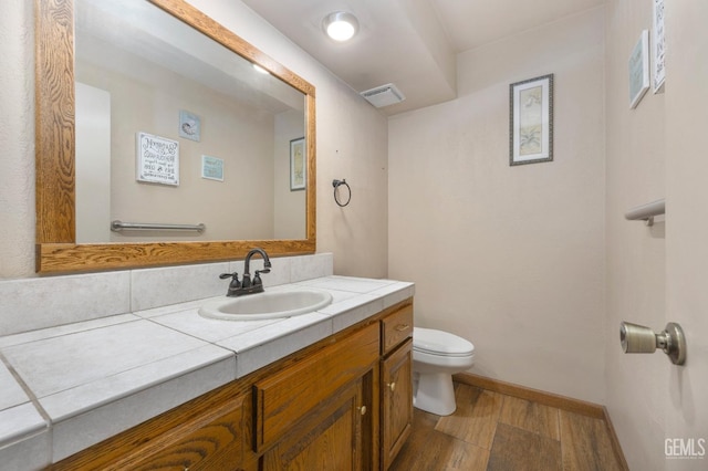 bathroom featuring vanity, hardwood / wood-style flooring, and toilet