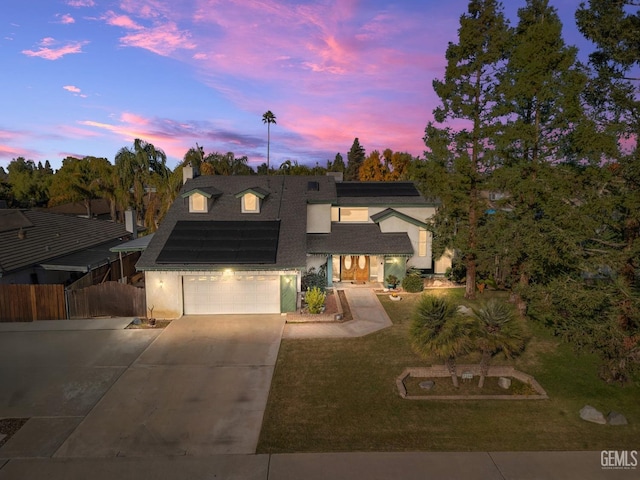 view of front of property featuring solar panels and a yard