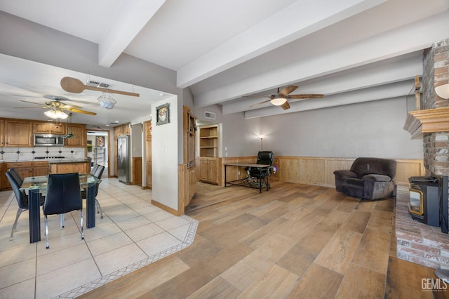 dining space featuring ceiling fan, beam ceiling, and light hardwood / wood-style flooring