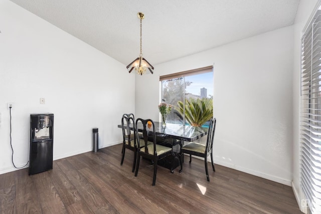 dining room featuring lofted ceiling, dark hardwood / wood-style floors, a textured ceiling, and a chandelier