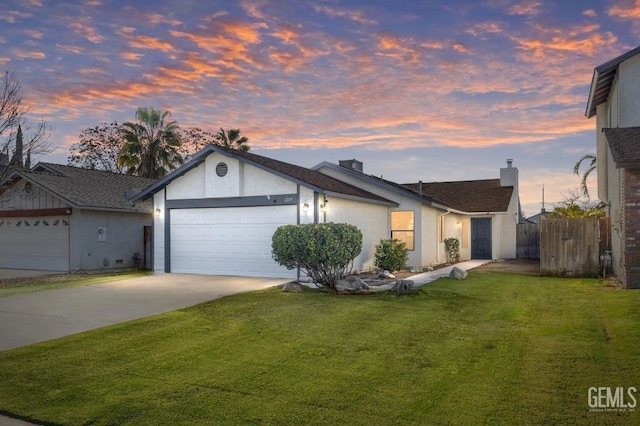 ranch-style house featuring a garage and a lawn