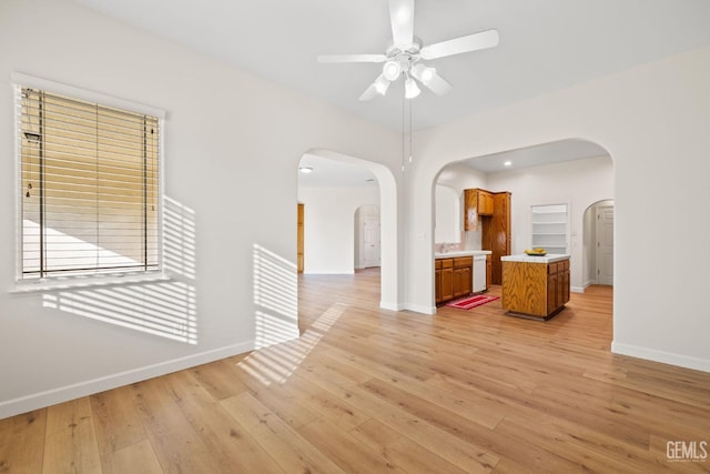 empty room with ceiling fan and light hardwood / wood-style floors