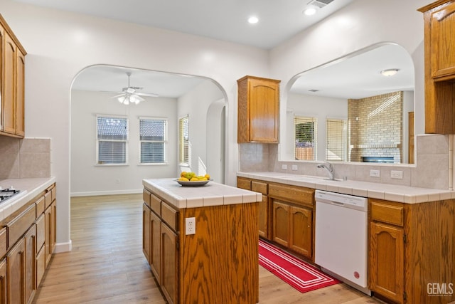 kitchen featuring dishwasher, a kitchen island, decorative backsplash, and sink