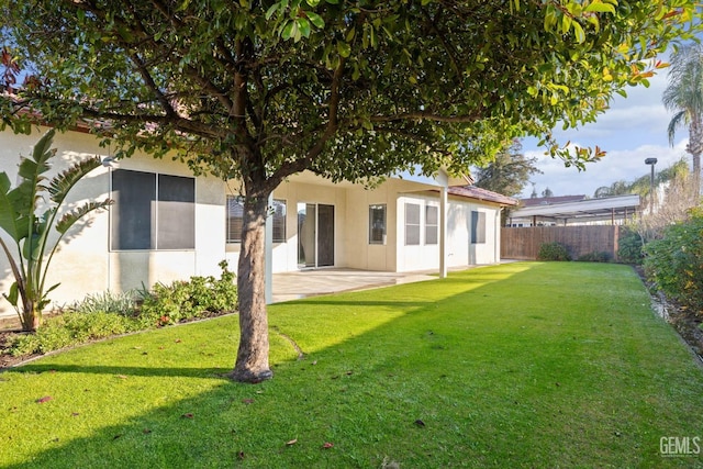 back of property featuring a yard and a patio