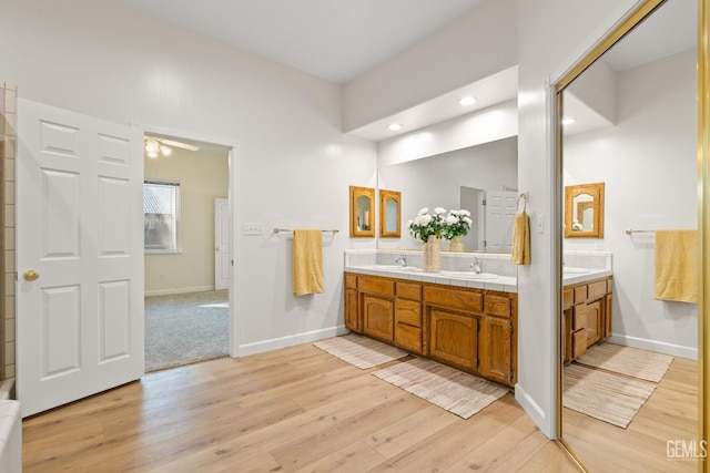 bathroom with wood-type flooring, vanity, and ceiling fan