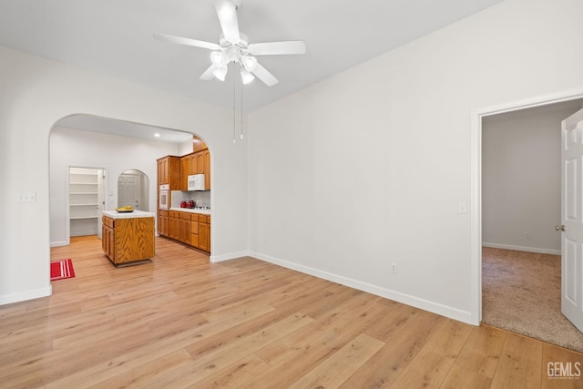 unfurnished living room with ceiling fan and light wood-type flooring