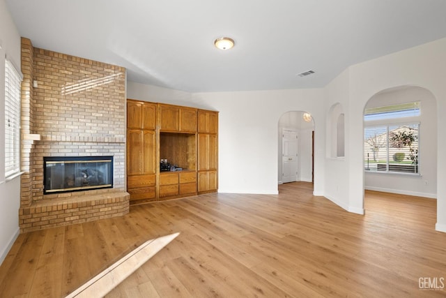 unfurnished living room with a fireplace and light wood-type flooring