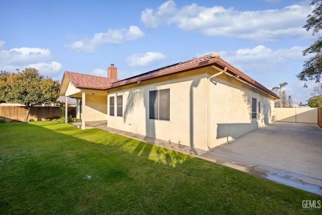 back of house with a yard and a patio