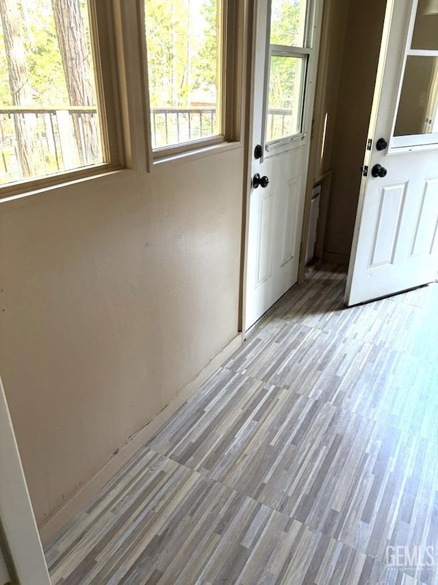 doorway to outside with baseboards and light wood-style floors