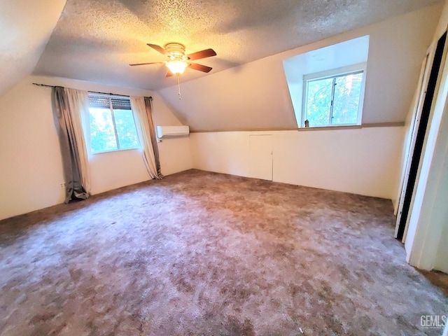 bonus room with a textured ceiling, ceiling fan, a wall mounted air conditioner, and vaulted ceiling
