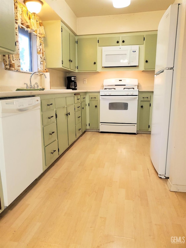 kitchen featuring light countertops, white appliances, light wood finished floors, and green cabinets