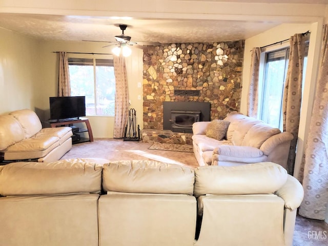 living room with ceiling fan and a wood stove