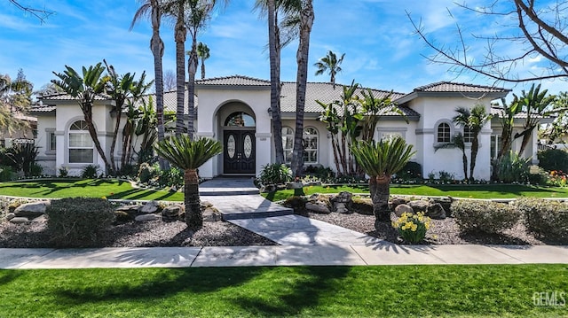 mediterranean / spanish-style house featuring stucco siding and a front yard