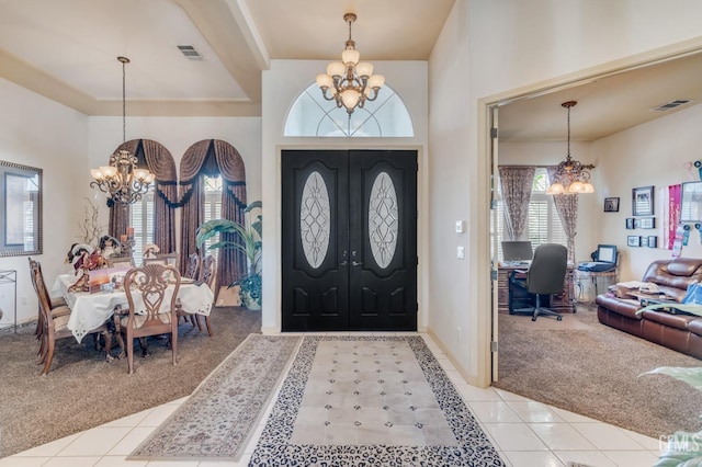 entryway featuring light carpet, visible vents, and a notable chandelier