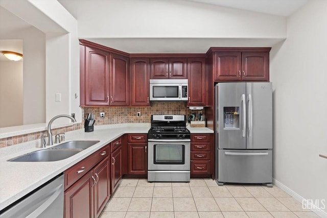 kitchen featuring tasteful backsplash, appliances with stainless steel finishes, light tile patterned flooring, and sink