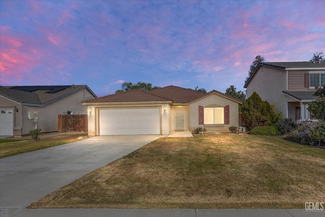 view of front of property featuring a garage and a lawn