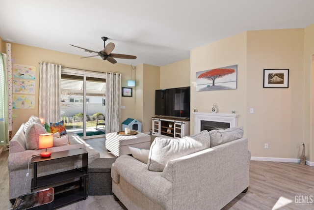 living room with light wood-type flooring and ceiling fan