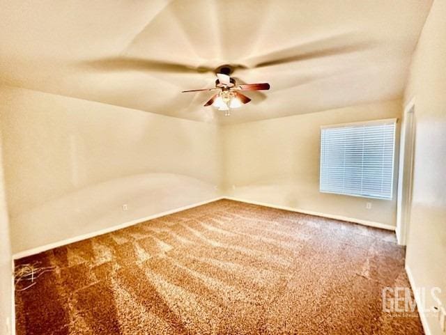 carpeted empty room with baseboards and a ceiling fan