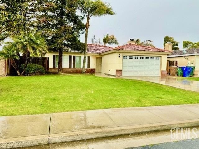 view of front of house with stucco siding, a front lawn, a tile roof, concrete driveway, and an attached garage