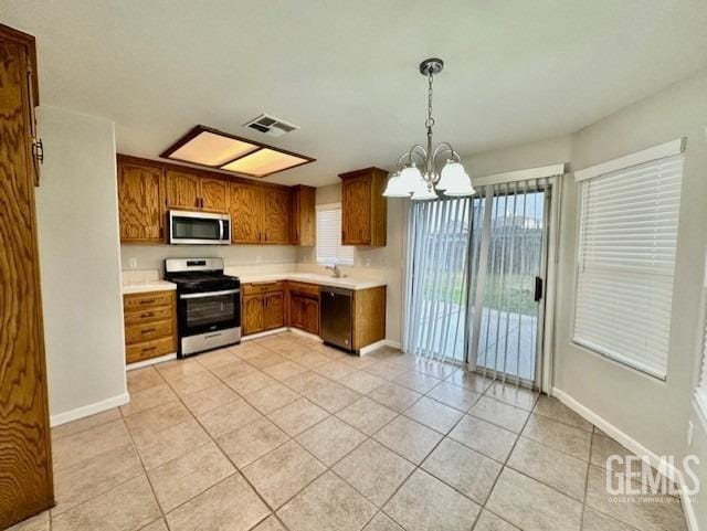 kitchen with visible vents, decorative light fixtures, light countertops, appliances with stainless steel finishes, and a notable chandelier