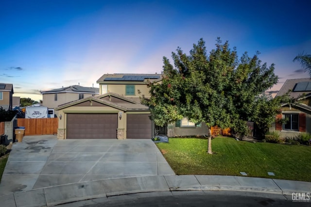 view of front of house featuring solar panels, a yard, and a garage