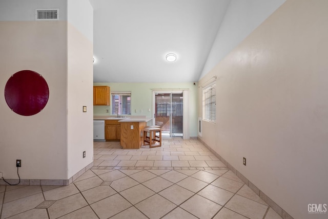 5414 Tyner Ln, Bakersfield, CA 93307 - kitchen with dishwasher, light countertops, a sink, a kitchen breakfast bar, and light tile patterned flooring