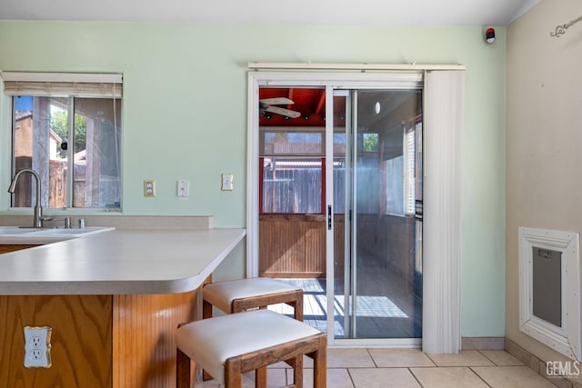 5414 Tyner Ln, Bakersfield, CA 93307 - kitchen featuring a sink, light tile patterned flooring, light countertops, and baseboards
