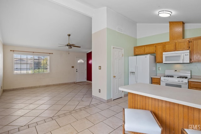 5414 Tyner Ln, Bakersfield, CA 93307 - kitchen with white appliances, light countertops, a ceiling fan, high vaulted ceiling, and light tile patterned floors