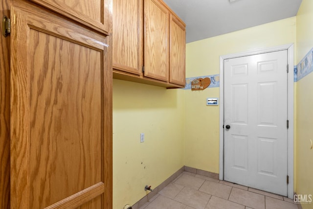 5414 Tyner Ln, Bakersfield, CA 93307 - laundry room featuring cabinet space, light tile patterned floors, and baseboards