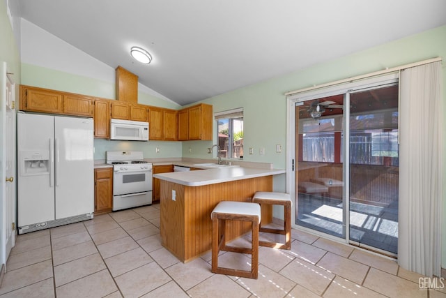 5414 Tyner Ln, Bakersfield, CA 93307 - kitchen featuring white appliances, a peninsula, a sink, vaulted ceiling, and light countertops
