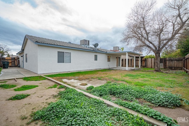 rear view of property featuring a yard and a patio