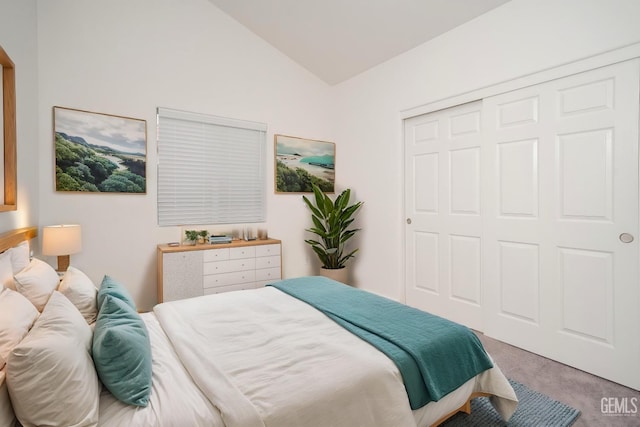 bedroom with a closet, lofted ceiling, and carpet