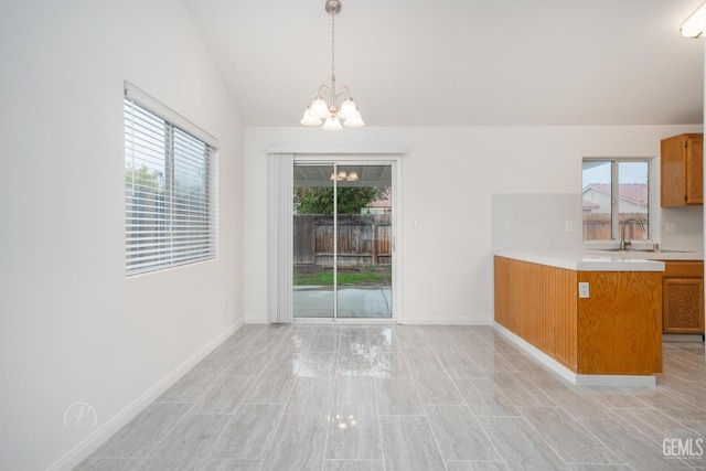 unfurnished dining area with sink, vaulted ceiling, and a chandelier