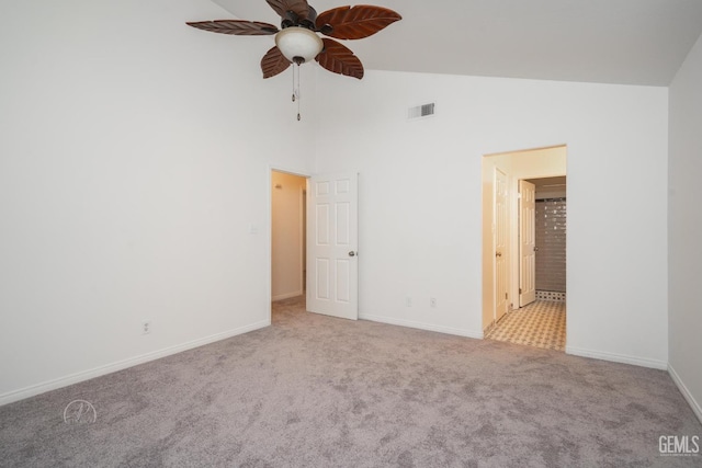 unfurnished bedroom featuring ensuite bath, high vaulted ceiling, and light carpet