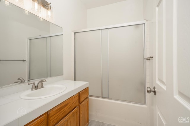 bathroom with vanity and shower / bath combination with glass door