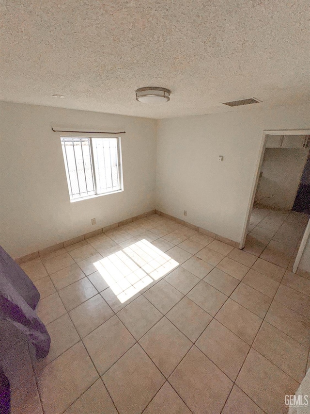 1065 12th St, Wasco, CA 93280 - unfurnished room with light tile patterned flooring and a textured ceiling