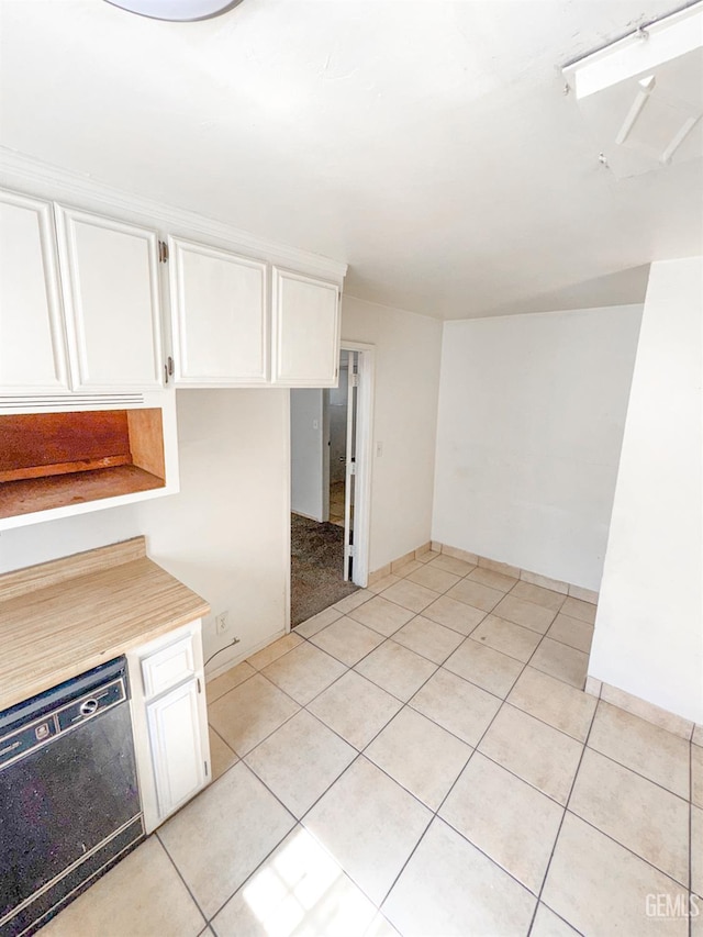 1065 12th St, Wasco, CA 93280 - kitchen featuring black dishwasher, white cabinetry, light tile patterned floors, and light countertops