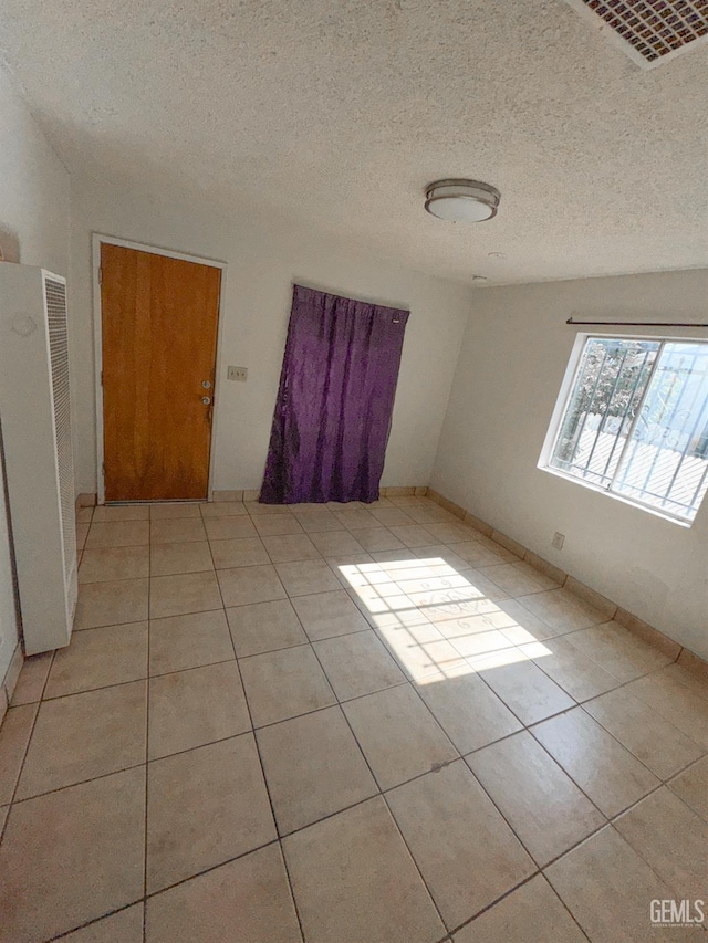 1065 12th St, Wasco, CA 93280 - spare room with a heating unit, light tile patterned floors, and a textured ceiling