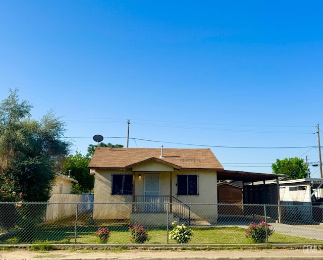 1065 12th St, Wasco, CA 93280 - bungalow featuring a fenced front yard, an attached carport, stucco siding, and concrete driveway