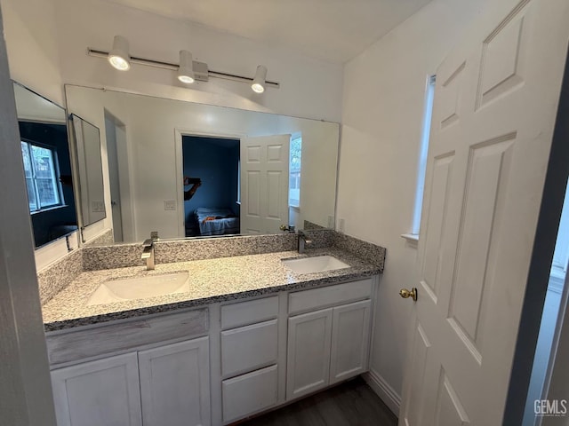 full bath featuring ensuite bathroom, double vanity, and a sink