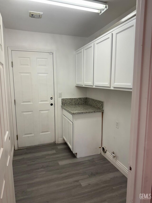 laundry room with cabinet space, dark wood finished floors, and visible vents