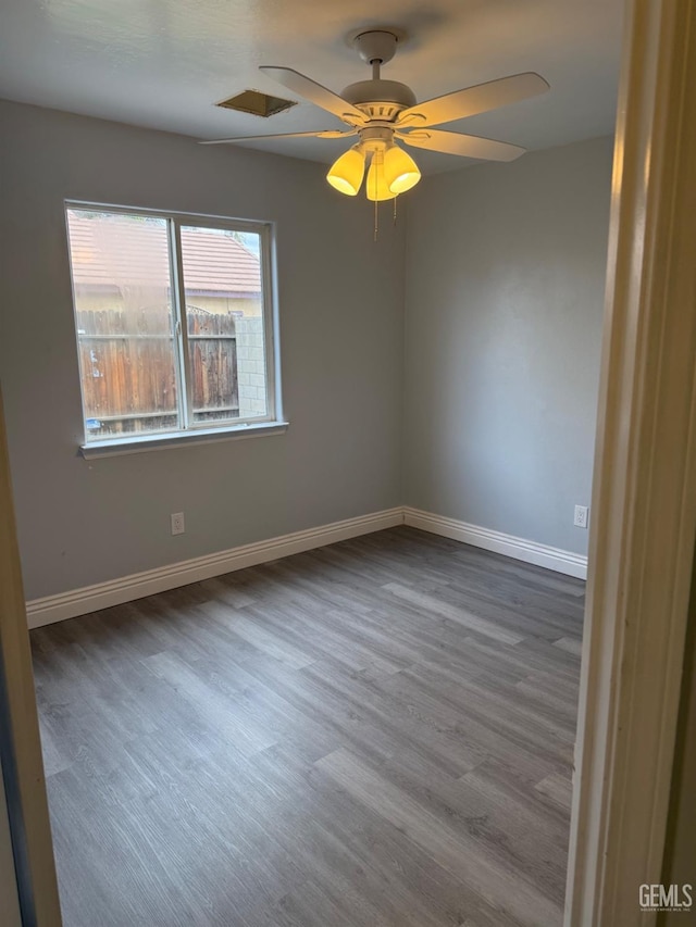 unfurnished room with ceiling fan, baseboards, and wood finished floors